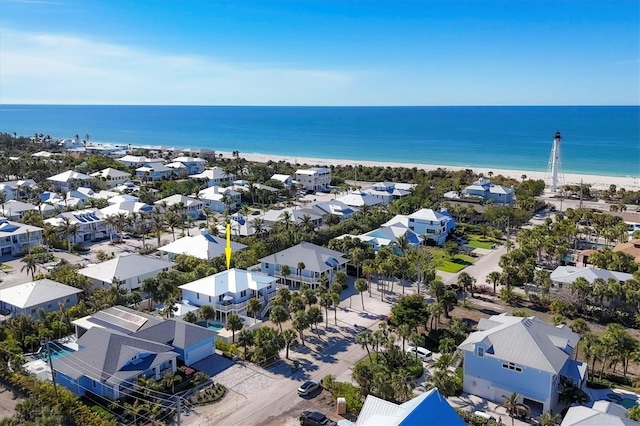 drone / aerial view featuring a water view and a view of the beach