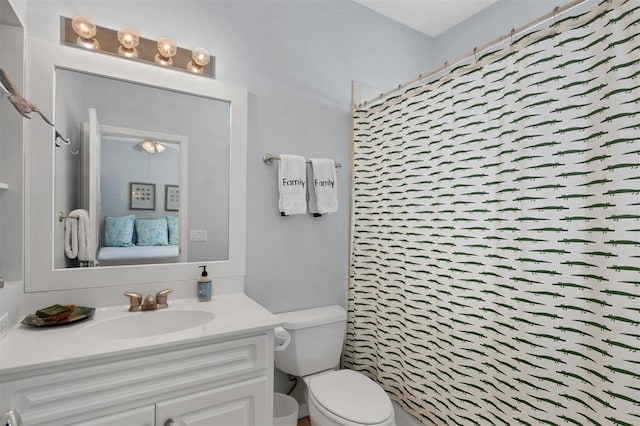 bathroom featuring curtained shower, vanity, and toilet