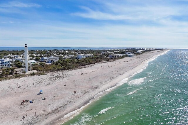 birds eye view of property with a water view and a beach view