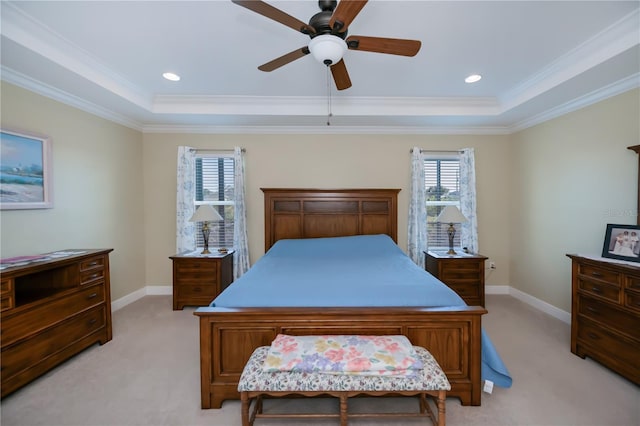 carpeted bedroom with ceiling fan, multiple windows, and a tray ceiling