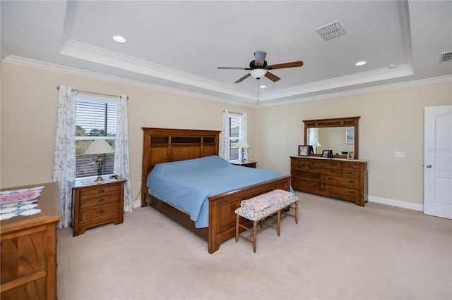 bedroom with ceiling fan, light colored carpet, and a tray ceiling