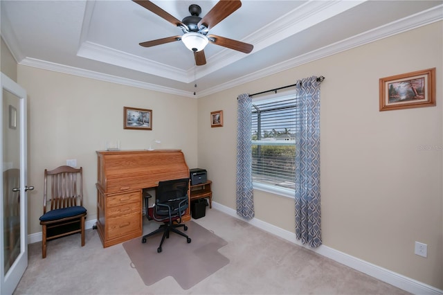 office area with ceiling fan, crown molding, a raised ceiling, and light carpet