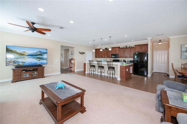 living room featuring light carpet, ceiling fan, sink, and ornamental molding