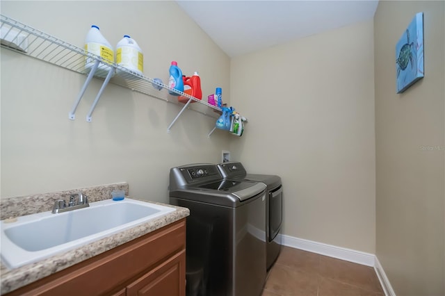 clothes washing area featuring cabinets, sink, dark tile patterned floors, and independent washer and dryer