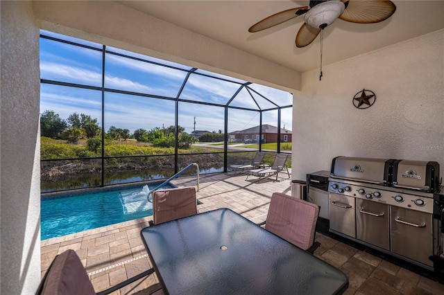 exterior space with glass enclosure, a water view, a patio, ceiling fan, and grilling area