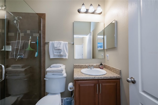 bathroom featuring toilet, a shower with shower door, and vanity