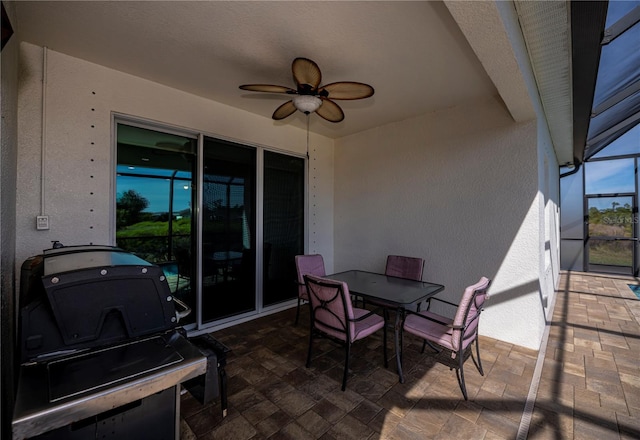 view of patio / terrace featuring ceiling fan and glass enclosure