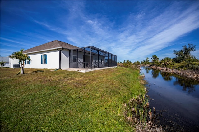 back of house featuring a water view, a patio area, and a yard