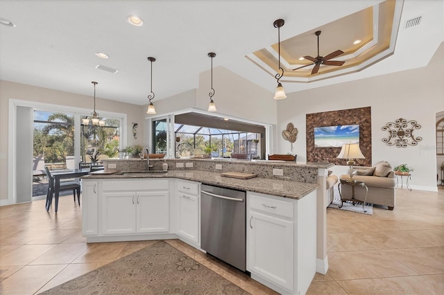 kitchen with white cabinetry, dishwasher, ceiling fan, a raised ceiling, and stone countertops