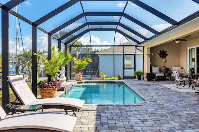 view of pool with a patio, ceiling fan, and a lanai