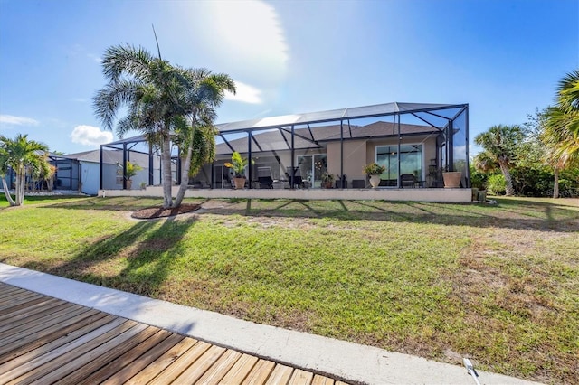 rear view of house with a lawn and glass enclosure