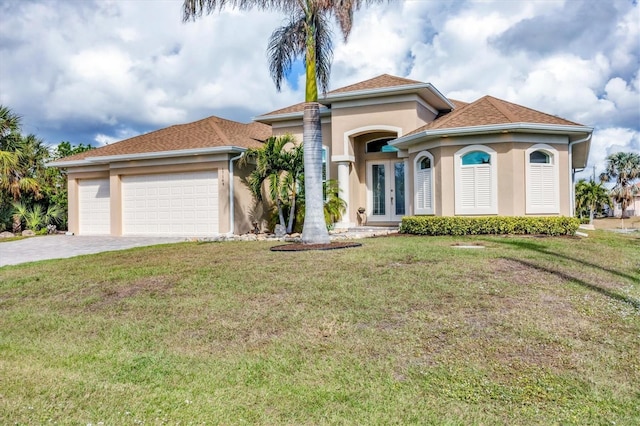 mediterranean / spanish house with french doors, a front lawn, and a garage