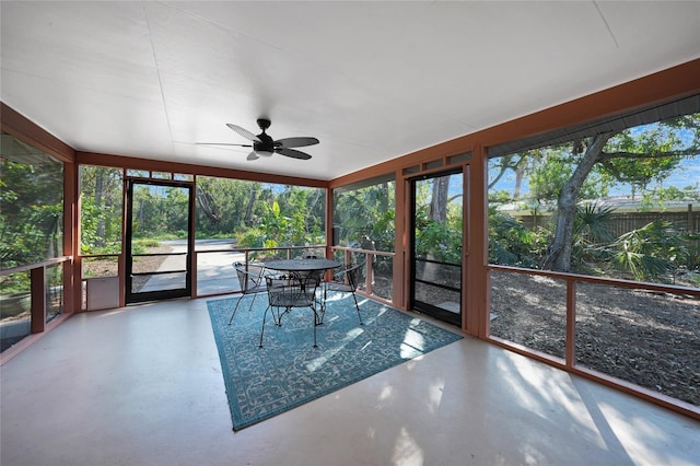 unfurnished sunroom featuring ceiling fan