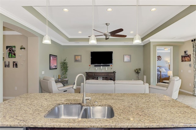 kitchen featuring pendant lighting, a tray ceiling, and sink