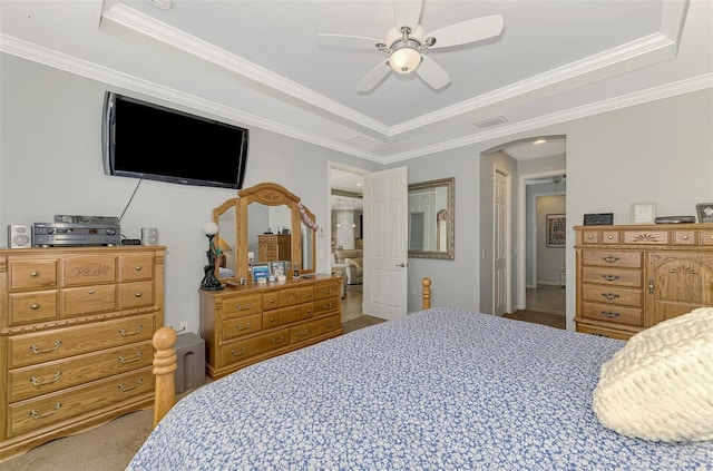 bedroom with ceiling fan, ornamental molding, and a tray ceiling