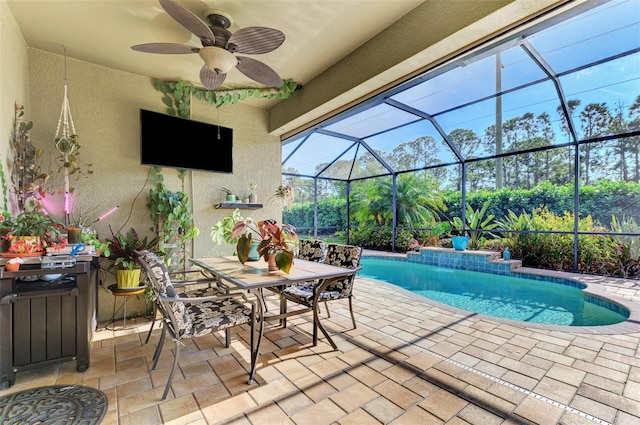 view of swimming pool with glass enclosure, ceiling fan, and a patio area