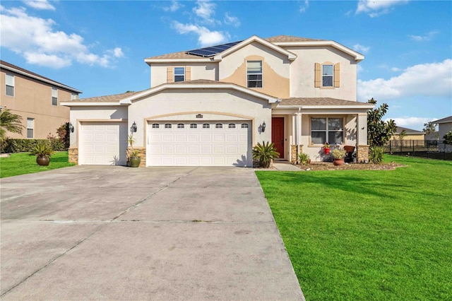 view of front of property with a front yard, solar panels, and a garage