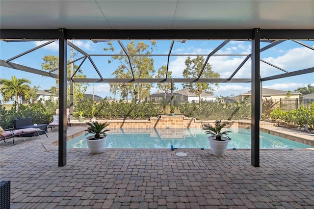 view of swimming pool featuring glass enclosure and a patio