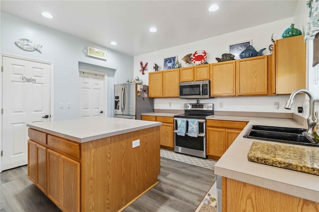 kitchen with appliances with stainless steel finishes, a center island, dark hardwood / wood-style flooring, and sink