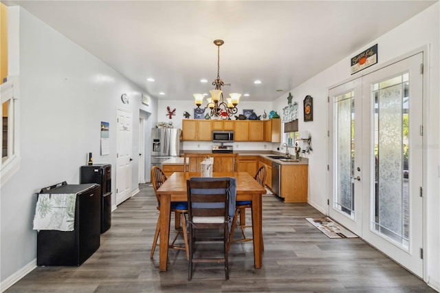 dining area with an inviting chandelier, dark hardwood / wood-style flooring, sink, and french doors