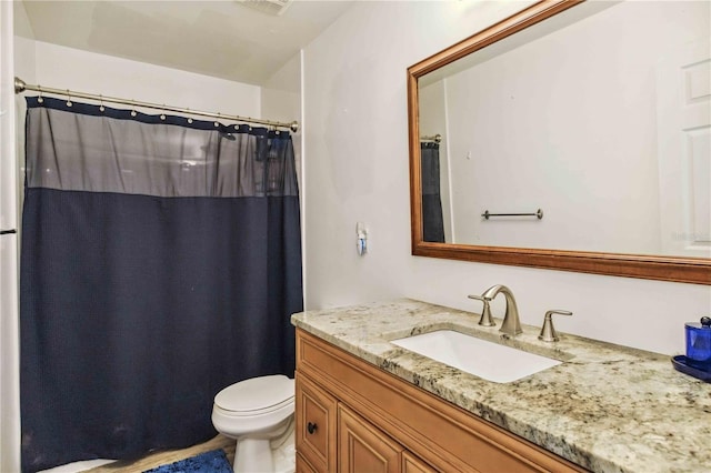 bathroom with vanity, curtained shower, and toilet