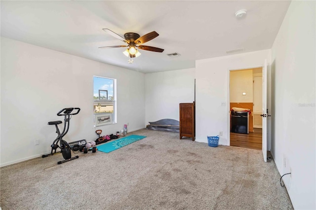 exercise room featuring light carpet and ceiling fan