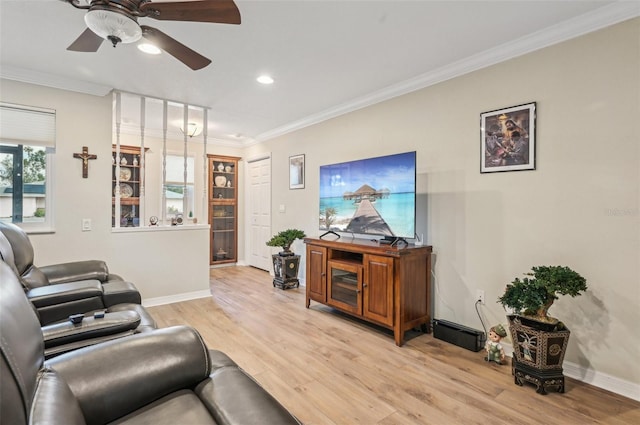 living room with ceiling fan, ornamental molding, and light hardwood / wood-style flooring