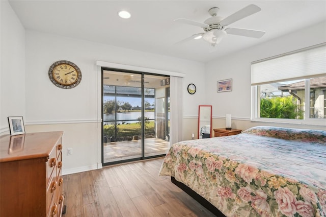 bedroom featuring ceiling fan, a water view, access to outside, and light hardwood / wood-style flooring