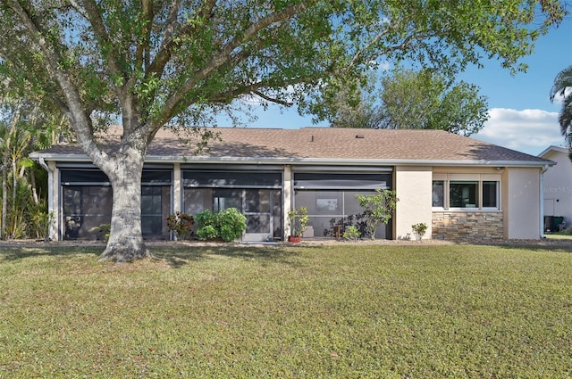 back of property with a yard and a sunroom