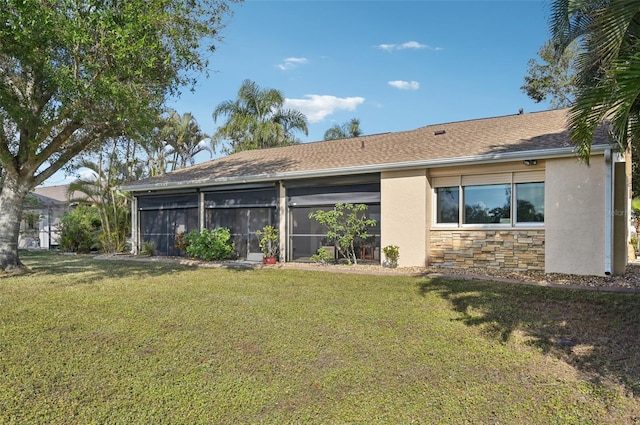 back of house with a yard and a sunroom