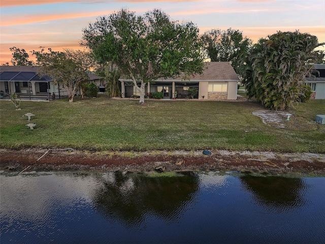 back house at dusk featuring a water view