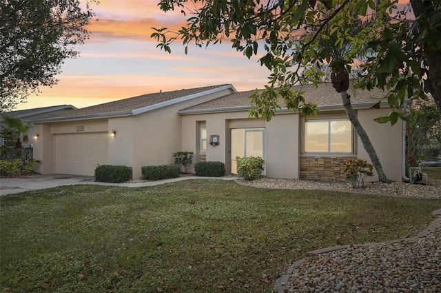 ranch-style home featuring a garage and a yard