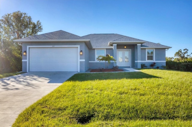 view of front of house with a garage, french doors, and a front lawn