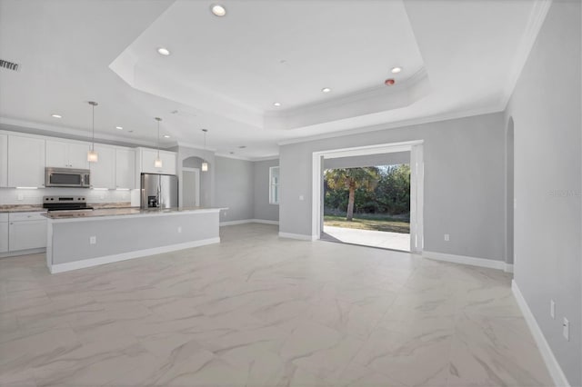 unfurnished living room with a raised ceiling and ornamental molding