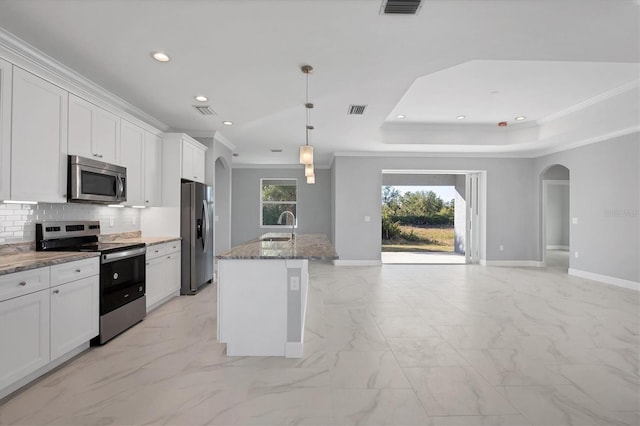 kitchen with a kitchen island with sink, crown molding, white cabinets, and appliances with stainless steel finishes