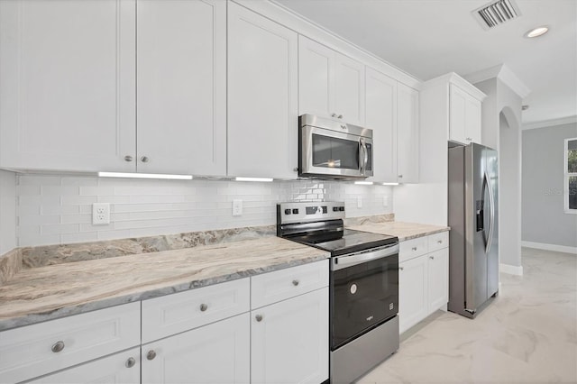 kitchen featuring stainless steel appliances, tasteful backsplash, light stone counters, crown molding, and white cabinets