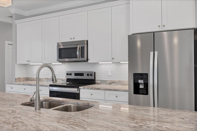 kitchen featuring stainless steel appliances, white cabinetry, ornamental molding, and sink