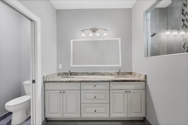 bathroom featuring a shower, tile patterned floors, vanity, and toilet