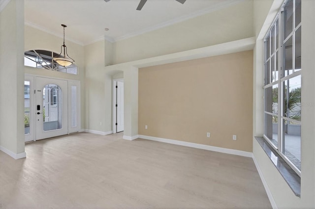 entrance foyer with a towering ceiling, light hardwood / wood-style flooring, ceiling fan, and ornamental molding