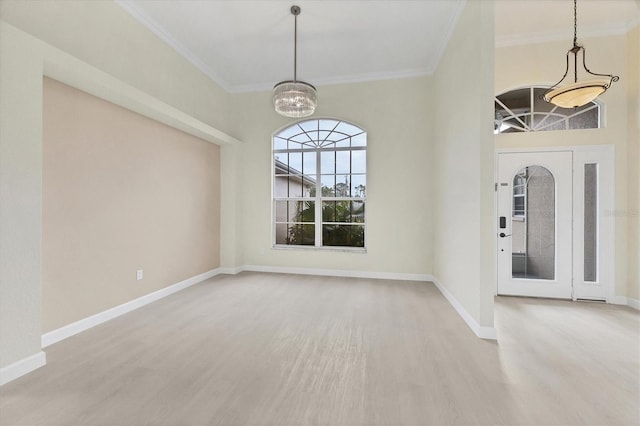 entrance foyer with a notable chandelier, wood-type flooring, and ornamental molding