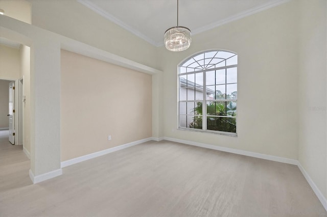 empty room with a notable chandelier, crown molding, and light hardwood / wood-style flooring