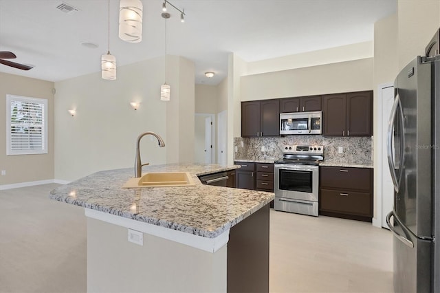 kitchen featuring sink, tasteful backsplash, decorative light fixtures, dark brown cabinets, and stainless steel appliances