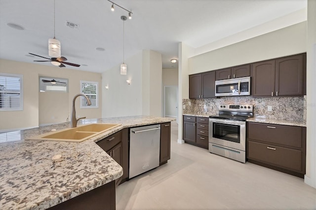 kitchen with backsplash, hanging light fixtures, sink, appliances with stainless steel finishes, and dark brown cabinets