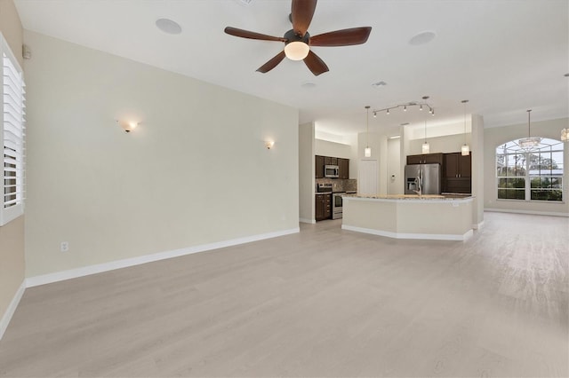 unfurnished living room featuring ceiling fan and light hardwood / wood-style flooring