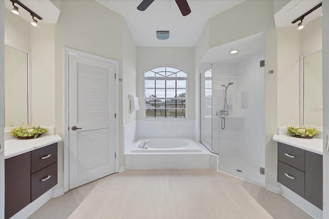 bathroom featuring ceiling fan, vanity, and plus walk in shower