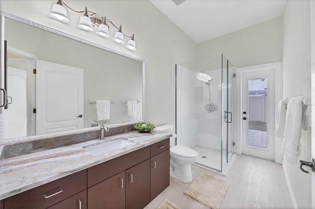 bathroom with vanity, toilet, lofted ceiling, and walk in shower