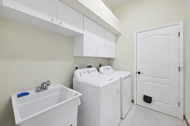 washroom featuring sink, cabinets, and independent washer and dryer