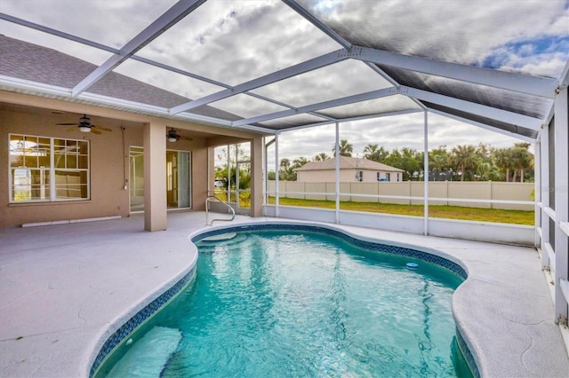 view of pool with glass enclosure, ceiling fan, and a patio area