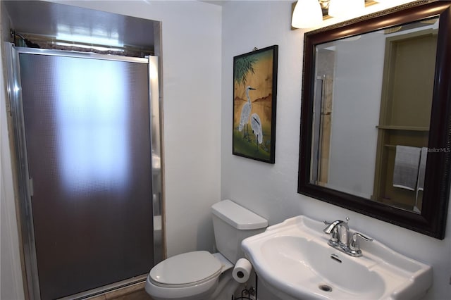 bathroom featuring sink, an enclosed shower, and toilet