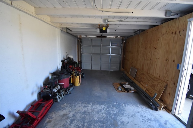 garage with a garage door opener and wooden walls